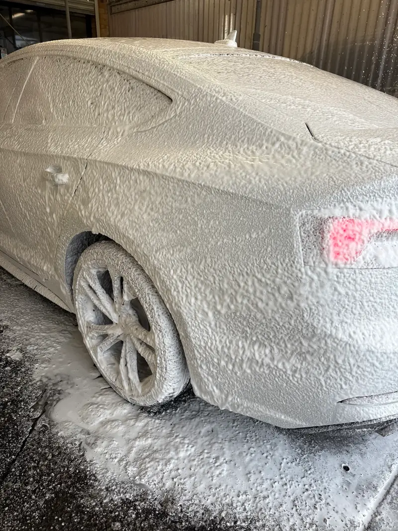 Car covered in snow foam during an exterior hand wash